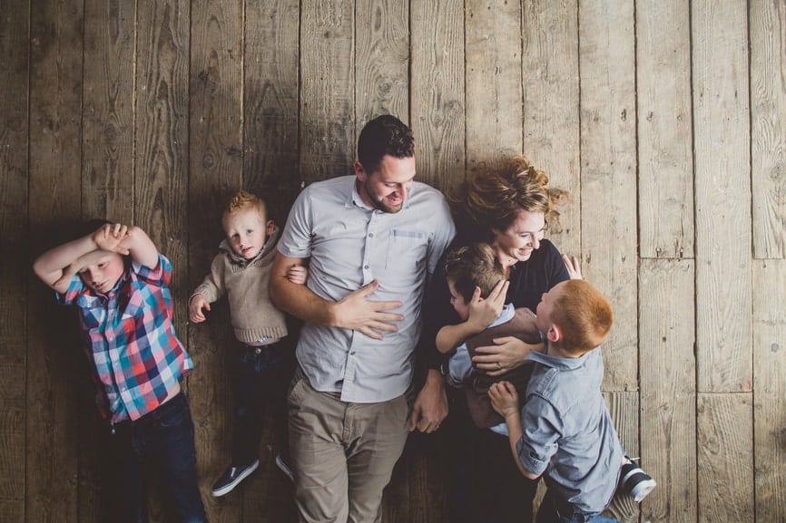 Family having fun tickling on old wood floor